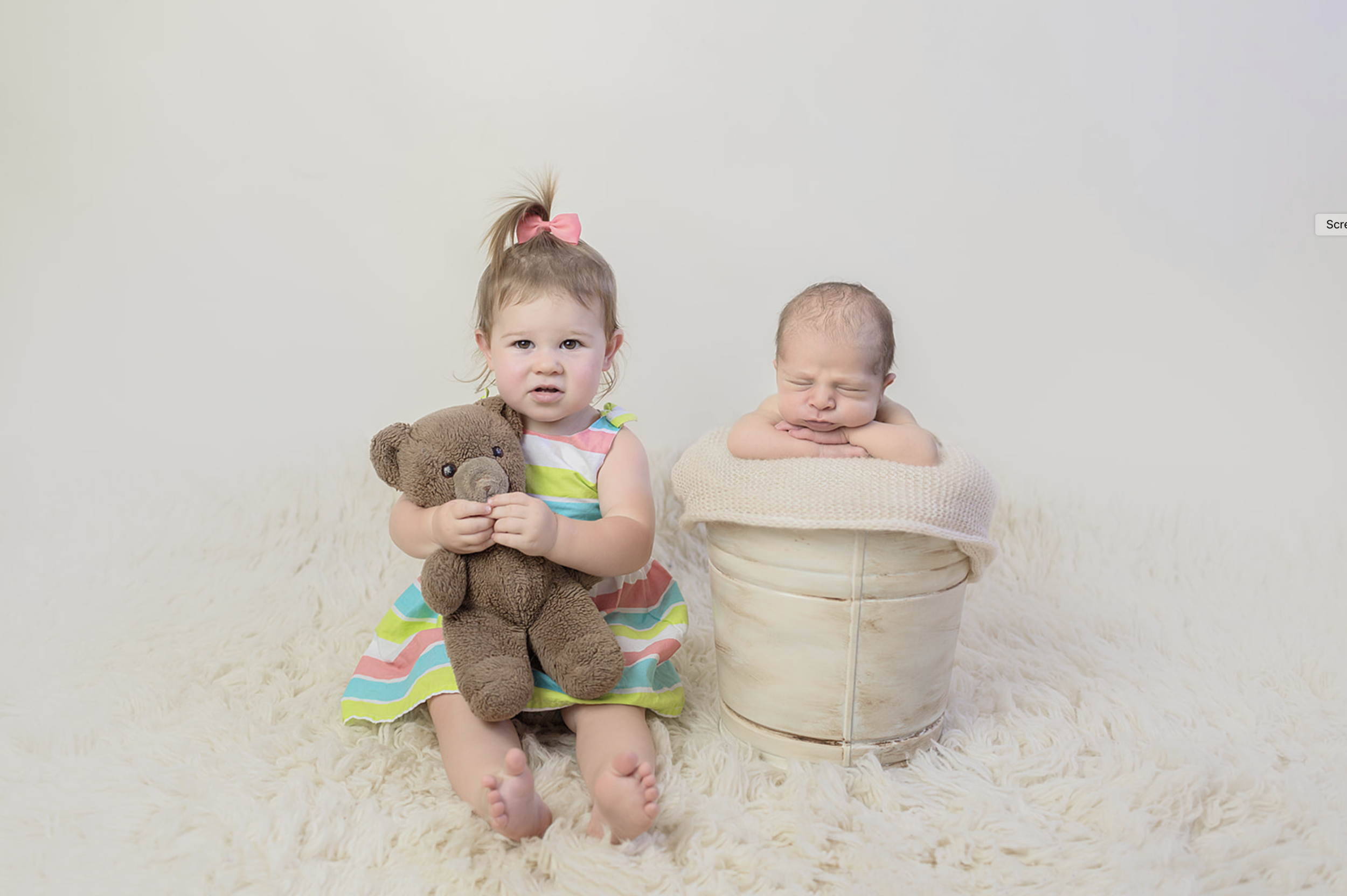Newborn Photo of older sibling and baby brother during newborn pictures with Luxury Newborn Photographer in San Diego