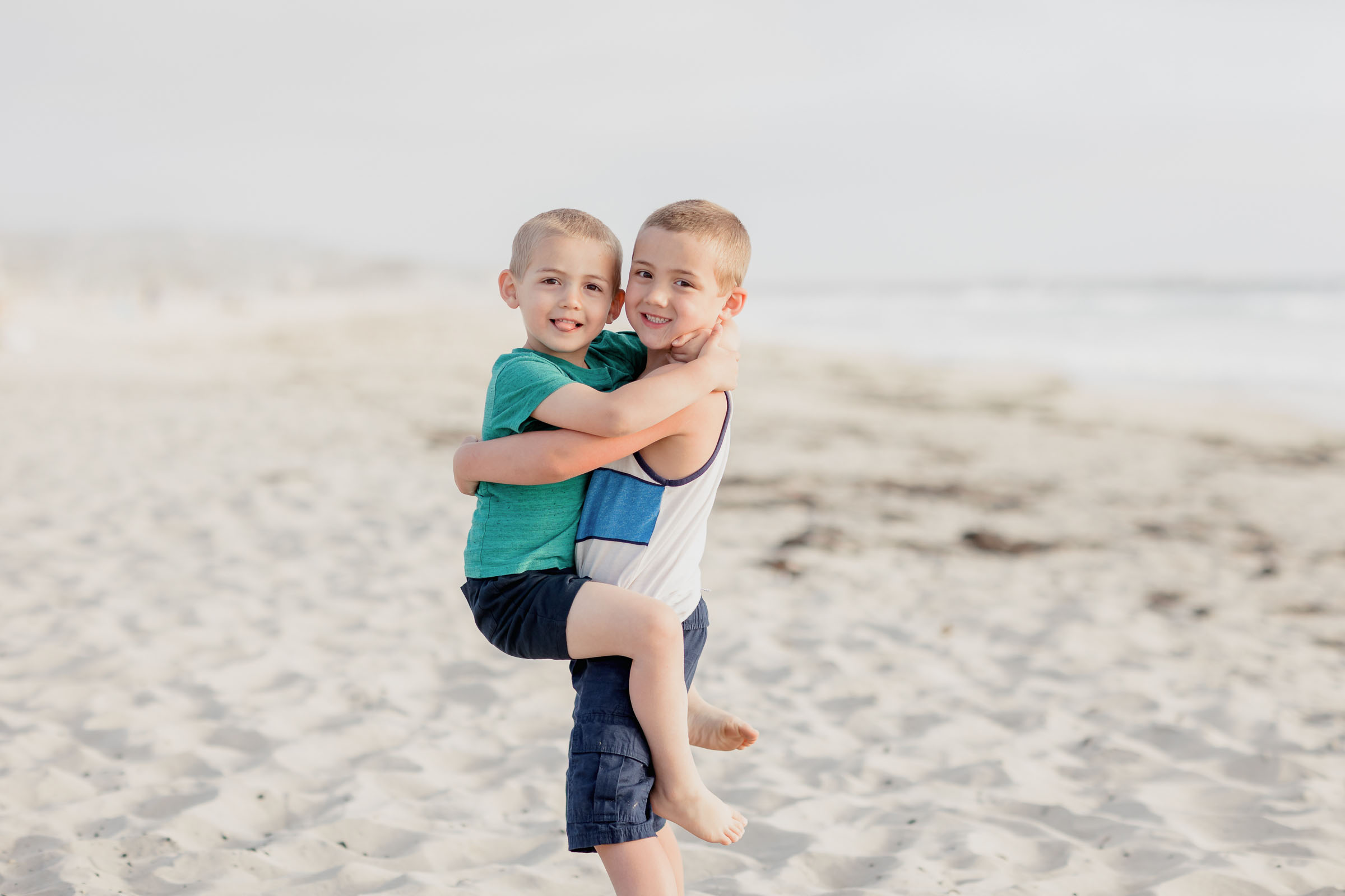 Cute image of two brothers hugging each other on the beach in La Jolla