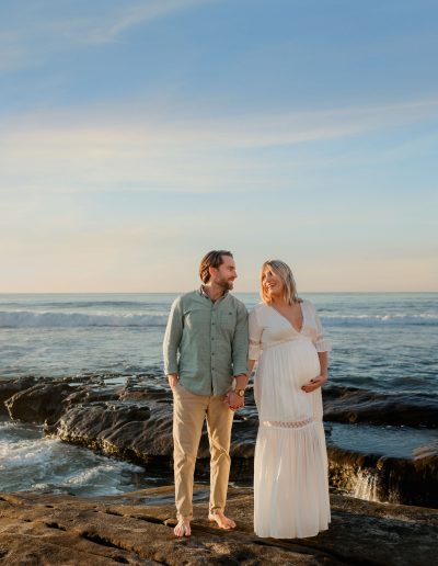 Mom and dad looking at each other during maternity pictures in La Jolla