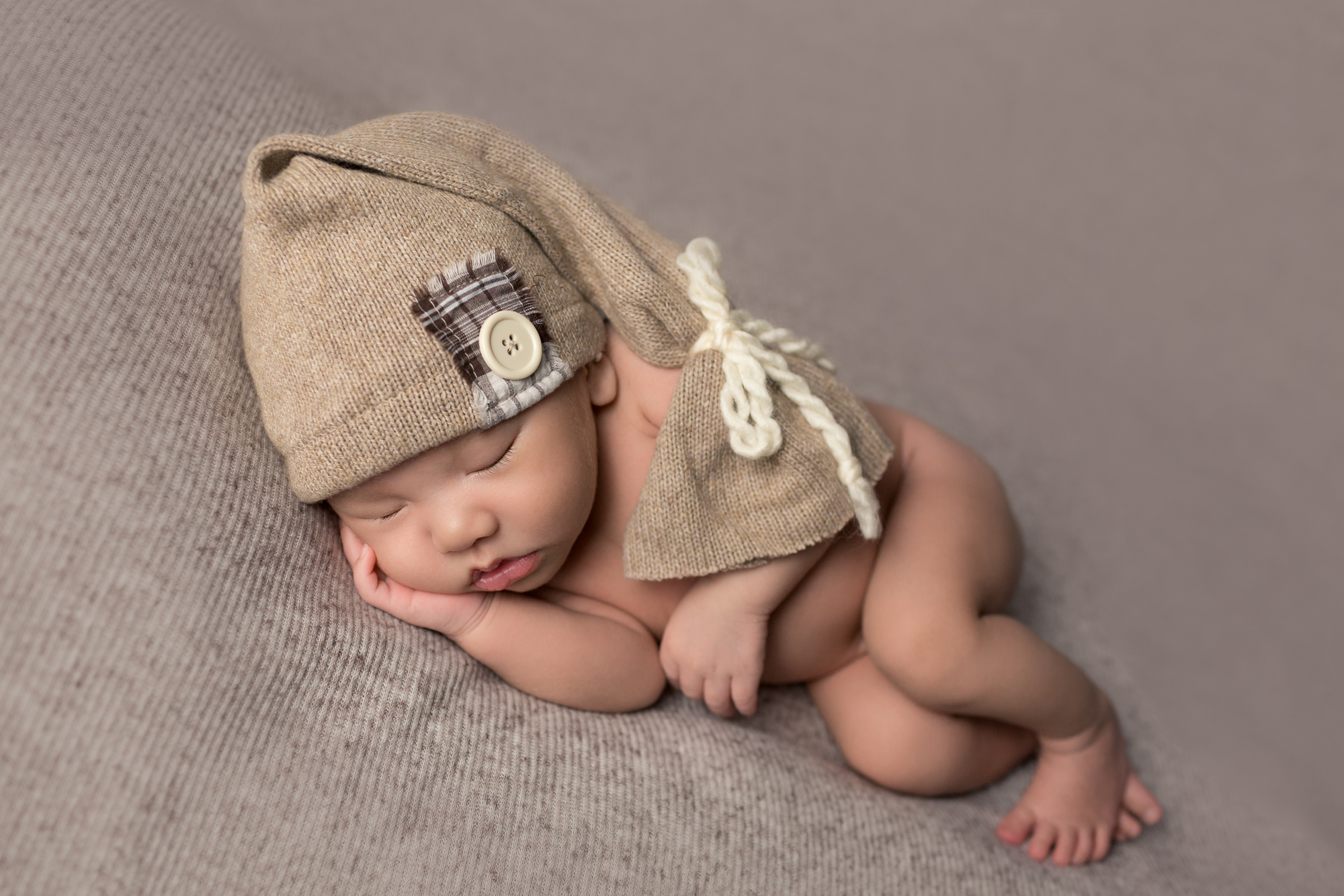 Newborn Baby Boy Rome with sleepy cap during newborn photography session in San Diego, CA