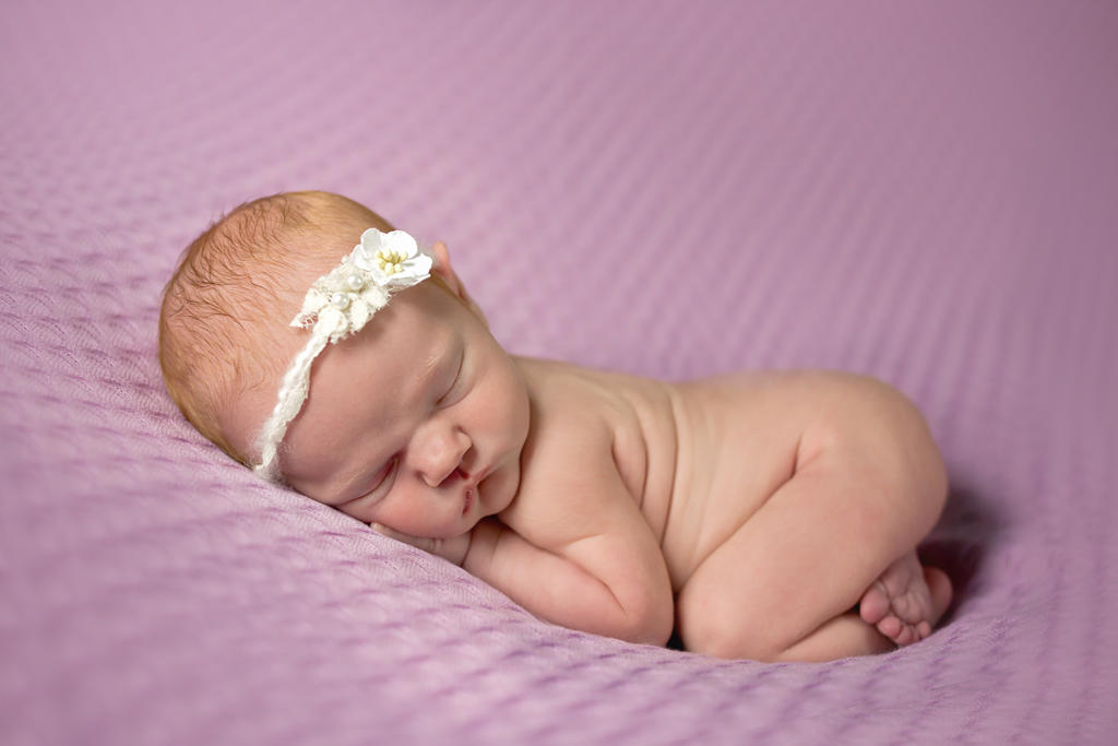 Newborn Pictures in San Diego CA Baby Girl doing Bum up Pose on Purple