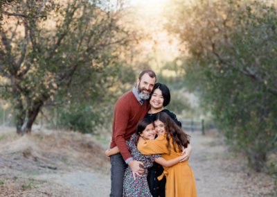 Imge of family hugging during family pictures in Mission Trails by San Diego Family Photographer