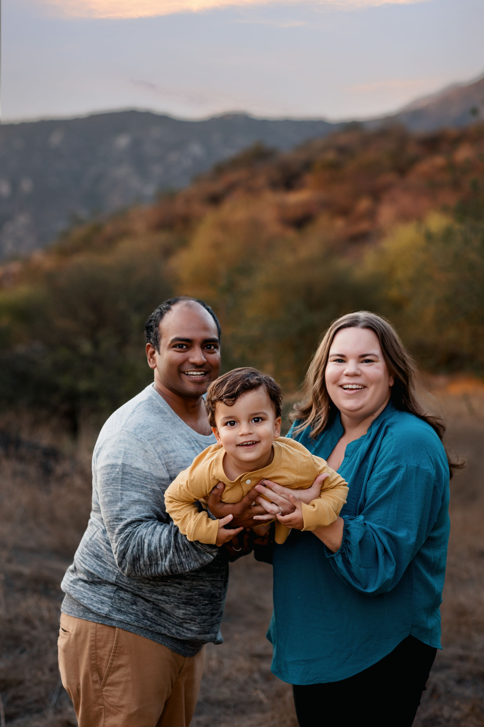 San Diego Family Photographer Pricing Website Image of family with mom and dad and son in the middle
