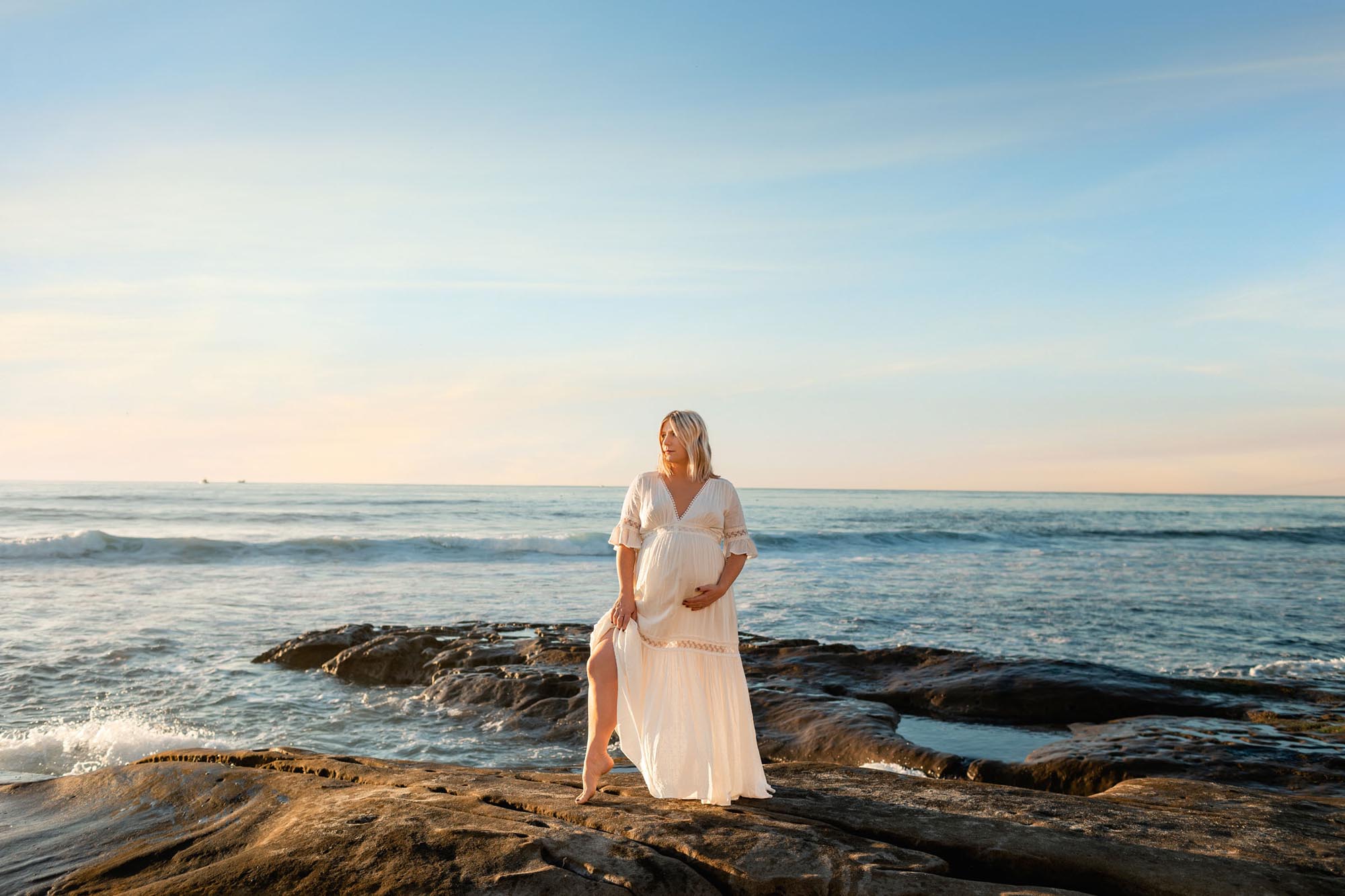 Pregnant mom standing on the cliffs at La Jolla Posing for her Maternity Pictures 