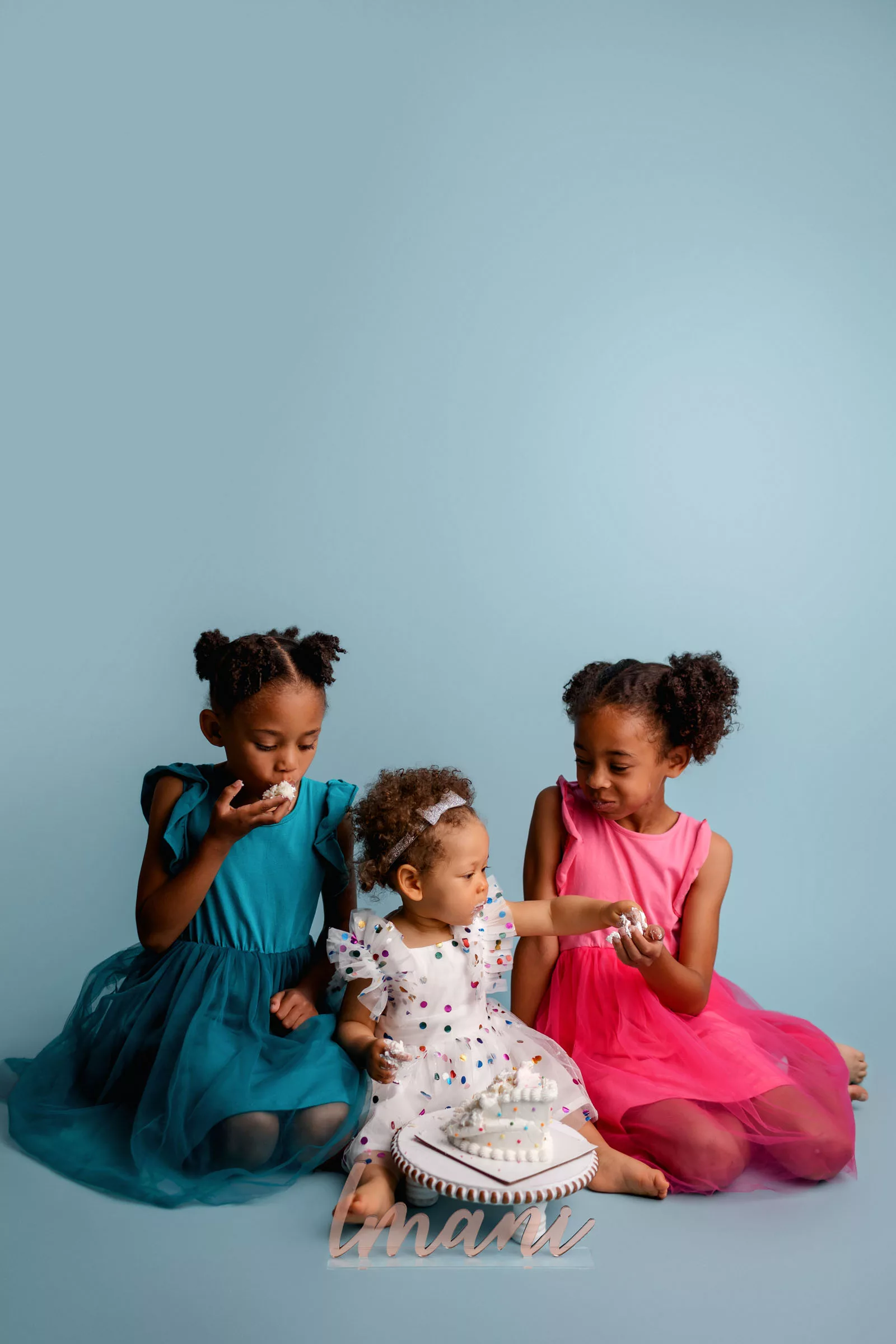 Portrait of three sisters enjoying a cake during a cake smash session in San Diego